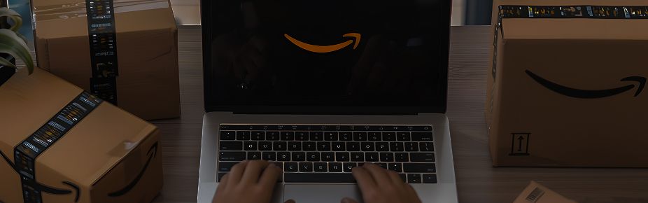 Compra online con el mejor courier Ecuador Persona usando laptop con logo de Amazon rodeado de cajas para envíos con el mejor courier en Ecuador